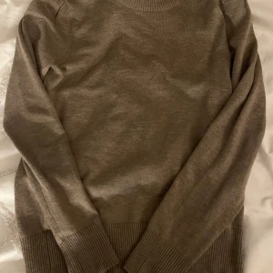 Brun stickad tröja från saint - Säljer en mysig brun stickad tröja från saint imycket bra skick. Den har långa ärmar och ribbade muddar vid ärmslut och nederkant. Perfekt för höst och vinterdagar när du vill hålla dig varm och stilren. Passar till både vardag och lite finare tillfällen.