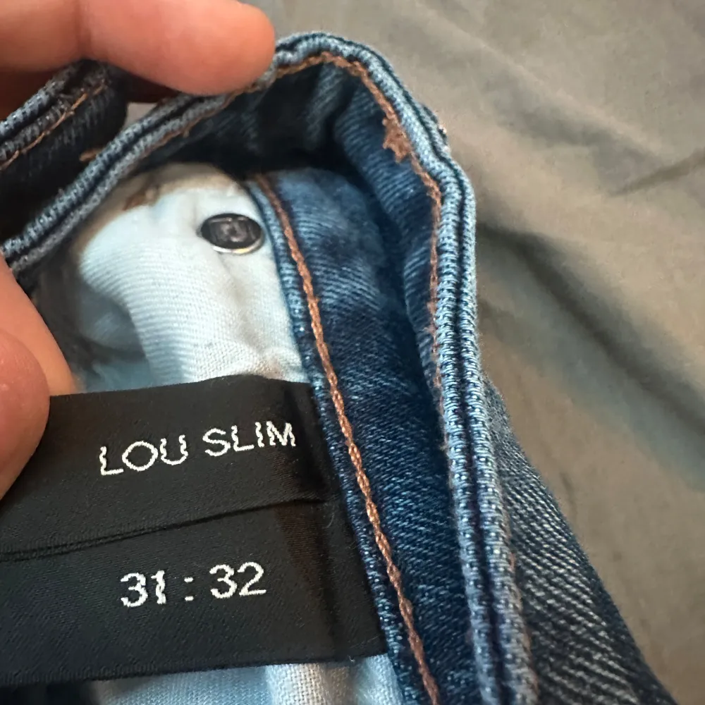 Säljer ett par snygga blå Lou Slim jeans i storlek 31:32. De har en klassisk femficksdesign med en slim passform och är i mycket bra skick. Perfekta för både vardag och fest! 🕺. Jeans & Byxor.