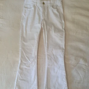 Vita bootcut jeans från Lindex - Säljer ett par vita bootcut jeans från Lindex i modellen Freja. Byxorna är knappt använda. Kedjan är guldfärgad så passar fint att matcha med guldsmycken💘
