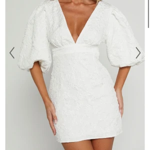 Vit kortklänning med puffärmar och struktur - Superfin vit kortklänning med v-ringning och stora puffärmar. Klänningen har en markerad midja och är sydd i ett strukturerat tyg som ger en lyxig känsla. Perfekt för sommarens alla tillfällen! Klänningen inhandlades för 1600 kr + frakt,  och är även endast provad, men jag har gått ner i pris🤍🤍