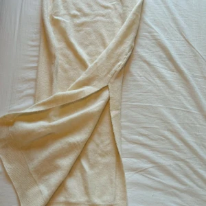 Lång stickad kjol - Säljer en creme/beige lång kjol i mjukt stickat material. Kjolen är lång och har slits på baksidan. Lite genomskinlig. Väldigt stretchig. Org pris 299