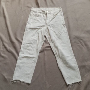 Vita croppade jeans från COS - Säljer ett par vita jeans från COS i modellen Slim med croppad längd och råa benslut. Byxorna har fem fickor, slim passform och midwaist. Perfekta för dig som gillar stilrena och enkla jeans med en modern twist. Färgen är varmvit mer åt beigea hållet med små strukturprickar, typ som linne ser ut