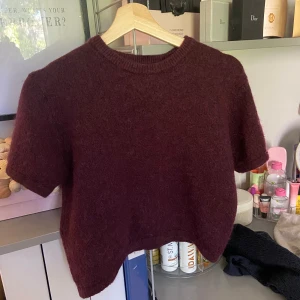 Vinröd croppad stickad tröja - Vinröd stickad tröja med korta ärmar och croppad passform så kan behövas ha ett linne under ❤️