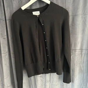 Svart kofta från Holly & Whyte - Jag säljer en fin svart kofta från Lindex köpt på Zalando. Koftan är i storlek S och använd ett få antal gånger. Mycket fint skick. Säljer pga att den aldrig kommer till användning.