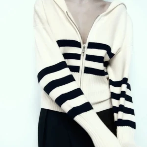 Vit och svart randig kofta från Zara - Säljer en ribbad kofta från Zara i vitt med mörkblå horisontella ränder. Tröjan har dragkedja framtill. Ny med prislapp kvar 🩵