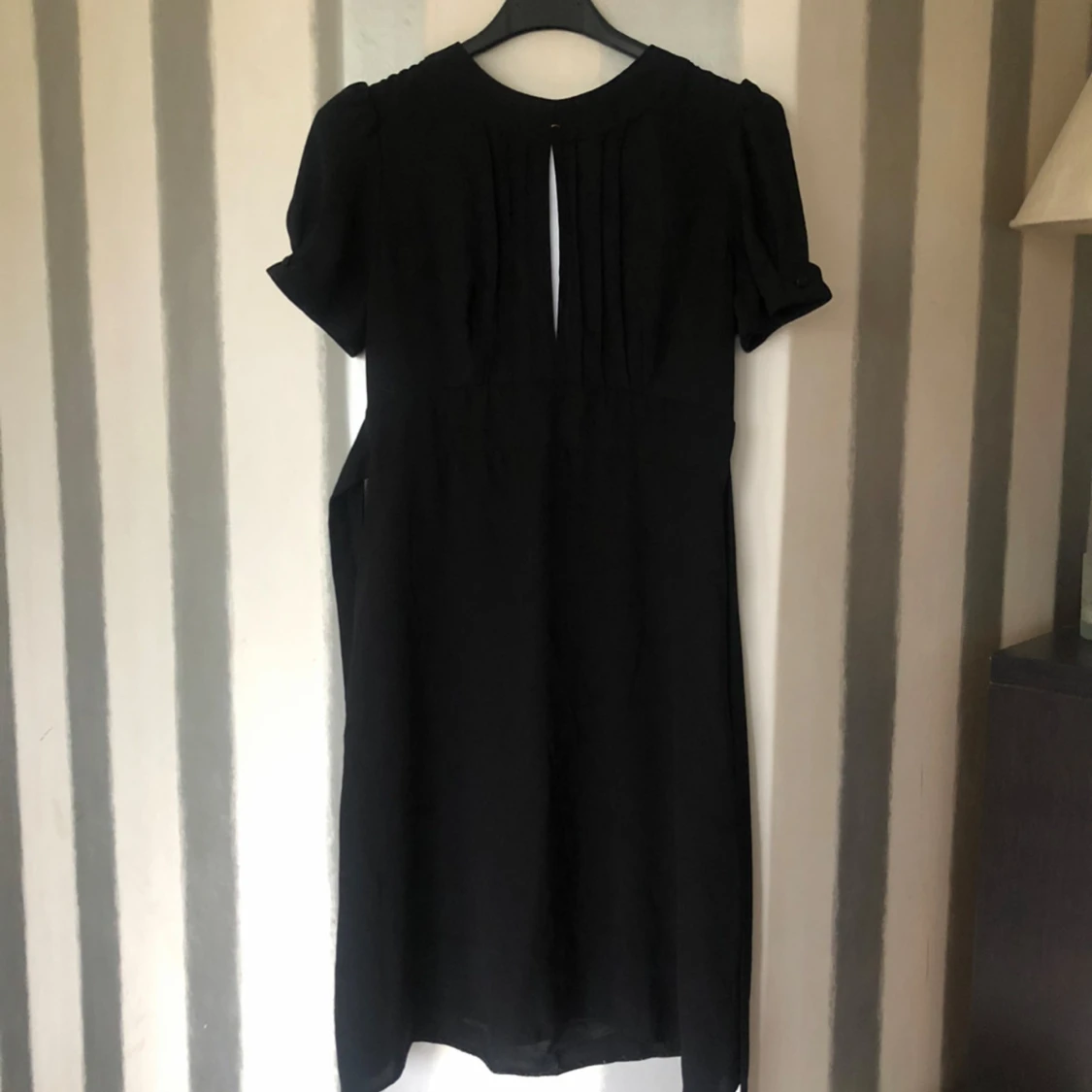 Svart klänning med kort ärm och knappdetalj