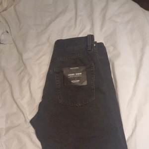 Svarta jeans från Jack & Jones - Säljer ett par svarta jeans från Jack & Jones, modell JJEEDDIE JJORIGINAL SBD. Jeansen har klassisk femficksdesign, raka ben och normal passform. Tillverkade i svart denim med diskreta sömmar och knappgylf. I storlek W28 L32 