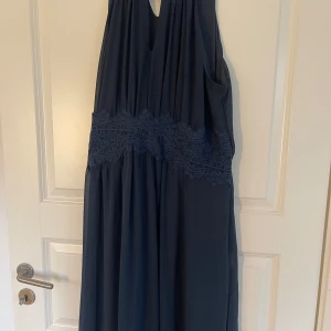  balklänning från Vila - Säljer en marinblå balklänning från Vila med spetsdetalj i midjan med glitter på sig. Passar 44/46 och är stretchig. Använd 1gång. Formar och faller fint på kroppen