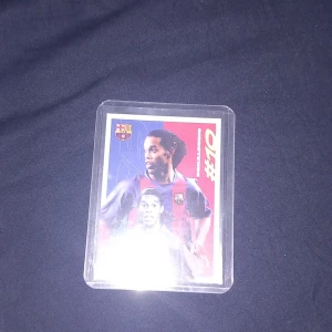 Ronaldinho fotbollssamlarkort FC Barcelona - Säljer ett exklusivt samlarkort från Topps med Ronaldinho i FC Barcelonas matchtröja. Kortet har klubbens logga och är designat i rött, blått och vitt. Perfekt för dig som samlar på fotbollskort eller älskar Barcelona.