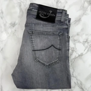 Jacob Cohën 31 - Gråa Jacob Cohën Style 688 jeans i storlek W31 i mycket fint skick. Jeansen har inga lagningar eller skavanker och är otroligt välhållna. Tveka inte på att höra av dig för fler bilder eller vid minsta fundering! Självklart äkta. Skick: 9/10 | Mått A: 39,5cm | Mått B: 101cm | Mått C: 80cm  