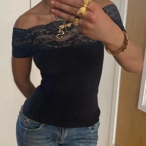 Svart offshoulder topp med spets - Säljer en skitsnygg svart offshoulder topp med spets. Tröjan är i storlek S och knappt använd hör gärna av dig💗.