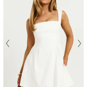 Vit kortklänning med rosett i ryggen - Säljer denna fina sommarklänning som passar perfekt till student och midsommar. Klänningen är helt oanvänd med prislappen kvar! 