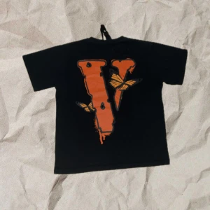 Svart VLone T-Shirt - Svart VLONE t-shirt med orange V på ryggen. Nästan aldrig använd – i mycket fint skick. Storlek S.