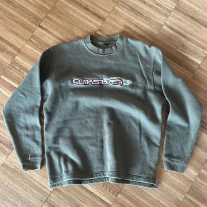Vintage Quiksilver Crewneck  - En vintage Quiksilver crewneck i storlek M. Tröjan är i fint skick utan några skador men en liten missfärgning vid kragen som förmodligen är blekningsmedel. Vid fler frågor eller mått tveka inte att kontakta oss!
