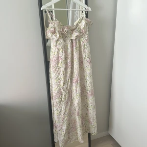 Hm långklänning med blommor - Populär klänning från H&M, med blommor och volang!! Trendig klänning