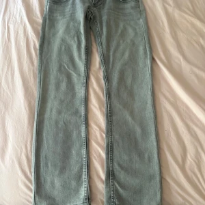 Ljusgrå jeans från Pepe Jeans - Snygga ljusgrå jeans från Pepe Jeans med klassisk femficksdesign och raka ben. Jeansen har dubbla knappar i midjan och diskret logga på bakfickan. Perfekta för en chill och stilren look. De passar någon som är runt 150 och de är lågmidjade 