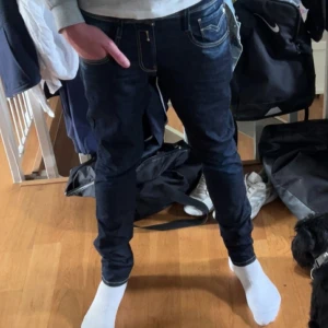 Replay Anbass Hyperflex jeans mörkblå - Säljer ett par Replay Anbass Hyperflex jeans i mörkblå tvätt. Jeansen är slim fit med klassisk femficksdesign och snygga kontrastsömmar. Materialet är stretchigt och bekvämt, tillverkat av återvunnen bomull och polyester. Perfekta för dig som vill ha stilrena och moderna jeans. Jeansen är helt oanvända och prislapparna står kvar säljer för att de inte passade mig.