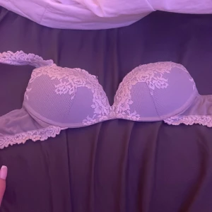 Intimissimi bh 75B - Nästan helt oanvänd. Säljer en vit/grå intimissimi bh med vacker spetsdetalj över kuporna och längs kanterna. Bh-n har en mjuk, feminin look med lätt vaddering. Perfekt för att bära under en öppen skjorta eller som den är till jeans.