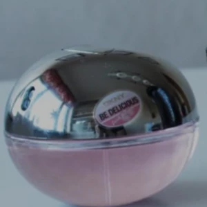 DKNY Be Delicious Fresh Blossom parfym - Säljer en DKNY Be Delicious Fresh Blossom parfym i en rund flaska med spegelblank silverfärgad topp och ljusrosa botten. Flaskan har en modern, äppelliknande form och är perfekt för dig som gillar fräscha och blommiga dofter.