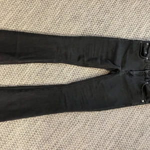 Svarta bootcut jeans 157 XS - Svarta jeans från 157 i modellen Low Boot, storlek XS. Byxorna har bootcut-ben och låg midja, klassisk femficksdesign och är tillverkade i stretchig denim för en skön passform. Perfekta för dig som gillar en tidlös och clean look.