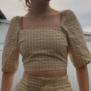 Ett super gulligt set med shorts och topp - Ett super gulligt beige/vit rutigt sätt! Så otroligt gulligt men inte min färg! Shorts 34 och topp xs, säljs tillsammans 