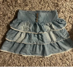 Blå volangkjol med spetsdetaljer - Köpte begagnad! Kan sälja för lägre pris vid snabb köp. Den är storlek 34 men är gjort av stretchiga material som gör att den passar också storlek 36 bra!💕💕