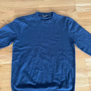 Blå stickad tröja från Primark - En stilren blå stickad tröja från Primark i storlek medium. Tröjan har rund halsringning och långa ärmar, perfekt för lager-på-lager. Enkel design utan mönster, passar dig som gillar en clean look.