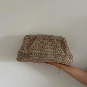 Beige stickad kuvertväska med kedja - Fin clutch som kan användas både med och utan band. Köpt från ett UF-företag som gör om väskor till clutches.  Har en liten lampa inuti som gör det lätt att se vad man har i väskan. I fint skick, säljs eftersom den inte kommit till användning.  Pris kan diskuteras! Skriv görna om du har frågor eller vill se fler bilder💕