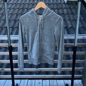 Grå hoodie med dragkedja från Cubus  - Mysig grå hoodie från Cubus i storlek XS. Tröjan har huva med snörning, dragkedja framtill och två fickor. Perfekt för chill dagar eller när du vill ha en enkel och stilren look. Tillverkad i mjuk bomullsblandning och har långa ärmar.