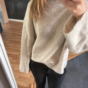 Beige stickad tröja - Supermjuk beige stickad tröja med avslappnad passform och långa ärmar. 