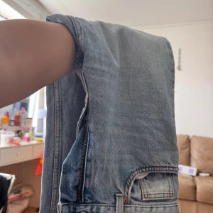 Ljusblå raka jeans i klassisk modell - Säljer ett par ljusblå jeans med raka ben och klassisk femficksdesign. Jeansen har normal midja, dragkedja och detaljer i kopparfärg. Perfekta för en chill och avslappnad stil. Materialet är robust denim i bomull.