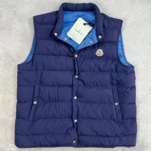 Moncler febe down vest - – Condition: 9,5/10 - used twice. Tags are still on.  - Size: 5/XXL  – Retail price: 9000 + SEK  Please note that Moncler runs small, we recommend going up one size from your usual size.