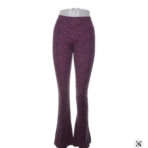 Mönstrade byxor från WE - Snygga byxor från WE med ett coolt mönster i rosa och svart. Byxorna har en bootcut-stil som ger en trendig look. Perfekta för att sticka ut med sin unika design. Kontakta för mer info🥰