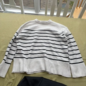 Vit och svart randig tröja - Säljer en vit tröja med svarta ränder. Tröjan har långa ärmar och en rund halsringning. Perfekt för en avslappnad stil.🌸💕🌸💕