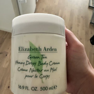 Elizabeth Arden Green Tea Honey Drops Body Cream - Stor burk med Elizabeth Arden Green Tea Honey Drops Body Cream. Denna kroppskräm kombinerar doften av grönt te med honungsextrakt för en återfuktande upplevelse. Perfekt för att ge huden näring och en fräsch doft.