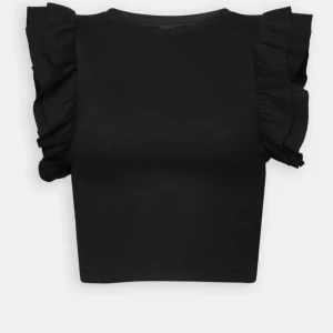 Svart ribbad topp med volangärmar - Snygg svart ribbad topp med volangdetaljer på ärmarna. Perfekt för att ge en trendig touch till din outfit. Toppen är croppad och har en tight passform.