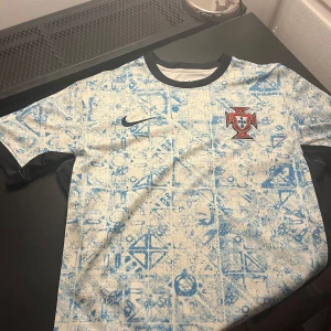 Portugal fotbollströja - En väldigt snygg fotbollströja med Portugals landslag på. Tröjan passar väldigt bra med ett par blåa jeans till sommaren.Inga defekte. Lågt pris!!