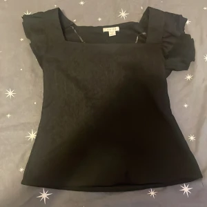 Svart topp från Amisu - Snygg svart topp från Amisu med korta ärmar och fyrkantig halsringning. Perfekt för en stilren look. Tillverkad i ett mjukt material som ger en bekväm passform.