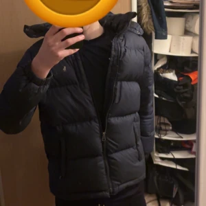 Ralph Lauren jacka - Säljer en mörkblå ralph lauren jacka storlek XS i helt okej skick som sitter bra. Finns lite små skador på ena armen och på sidan av jackan (se bilder) passar dig som är runt 165-175