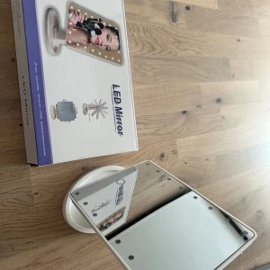 Stor LED-spegel med svart ram - Säljer en stor LED-spegel med svart ram. Spegeln har 22 LED-lampor som ger bra belysning för sminkning eller styling. Den är justerbar och har en stabil bas. Perfekt för att få till den rätta looken varje dag!