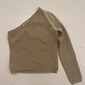 Guldig glittrig oneshoulder topp från NA-KD - Snygg guldig glittrig oneshoulder topp från NA-KD. 