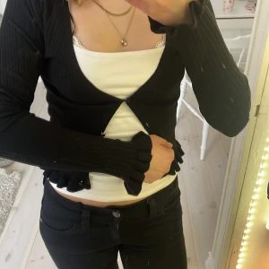 Svart ribbad kofta från H&M - Säljer en svart ribbad kofta från H&M med volang detaljer. 💓