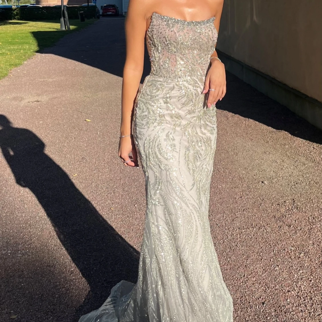 Glittrig axelbandslös långklänning