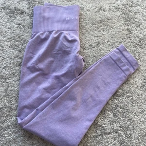 Lila leggings från NVGTN - Snygga lila leggings från NVGTN med hög midja och en tight passform. Materialet är väldigt mjukt och stretchigt. I bra skick💜💜dom passar xs-m, passformen lägger sig längst kroppen då de är väldigt stretchiga