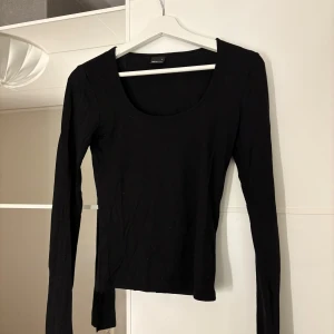 Svart långärmad topp från Gina Tricot - Snygg svart långärmad topp från Gina Tricot. Den har en rund halsringning och slits vid ärmarna. Hör av er vid funderingar eller om ni vill ha bilder med hur plagget sitter på mig.