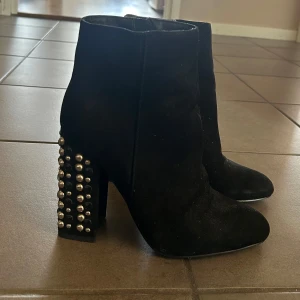 Svarta boots med nitdetaljer - Snygga svarta boots i mocka med klack med nitar på. De har en dragkedja på sidan för enkel på- och avtagning. Använd två gånger.