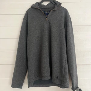 Grå halfzip från Polo Ralph Lauren - Säljer en stilren grå tröja från Polo Ralph Lauren med halv dragkedja och broderad logga. Perfekt för en avslappnad look. Tröjan har långa ärmar och är tillverkad i mjukt material för extra komfort. Mvh GrischBolaget👟