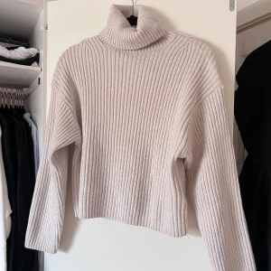 Beige ribbad polotröja från H&M - Säljer en stilren beige polotröja från H&M. Tröjan är ribbad och har en hög krage. Perfekt för kyligare dagar och enkel att matcha med olika outfits. Ett måste i garderoben för den som gillar klassiska plagg. Önskar du veta exakta mått? Tveka inte att höra av dig!