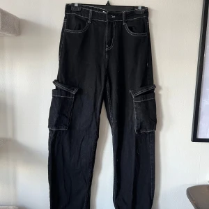 Svarta cargobyxor från Bershka - Snygga svarta cargobyxor från Bershka i denim med vita sömmar.