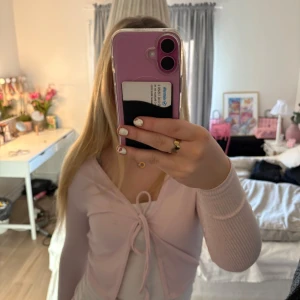 Rosa ribbad kofta från PrettyLittleThing - Säljer en söt rosa ribbad kofta från PrettyLittleThing. Den har långa ärmar och knytning framtill, perfekt för en stilren look. Passar bra till både jeans och kjol. 💖